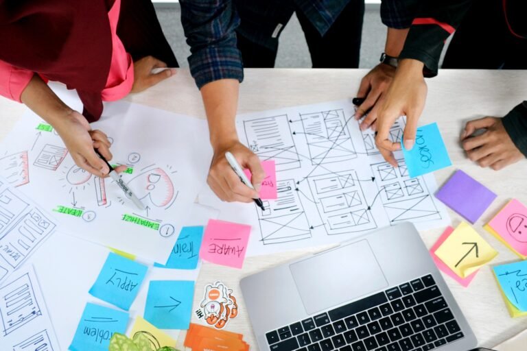 People leaning over a table with design papers