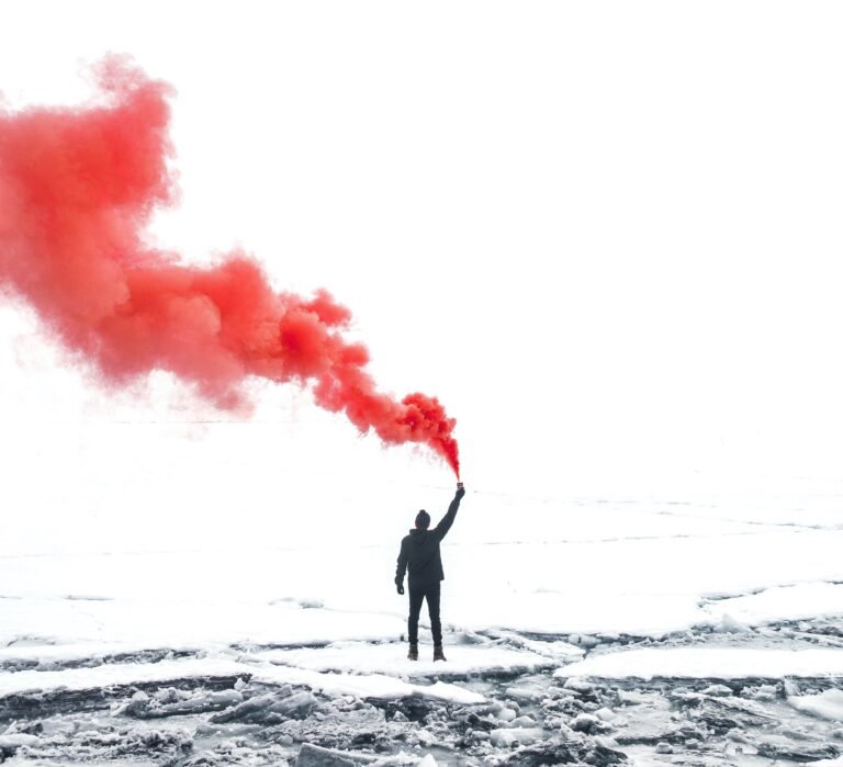 A man signaling with red smoke