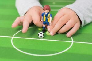 A PlayMobile kid kidding a soccer ball