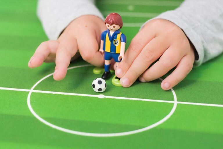 A PlayMobile kid kidding a soccer ball