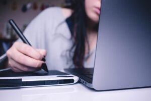 A woman working on her Mac and tablet