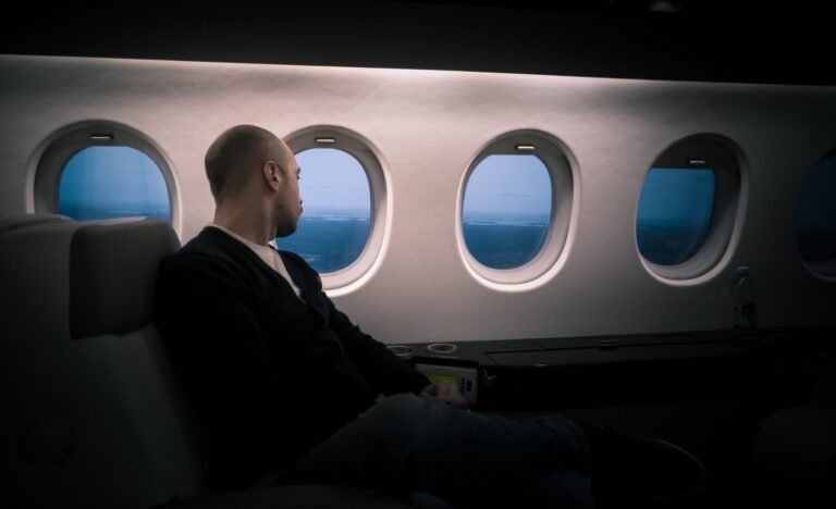 A man is looking out from a plane window