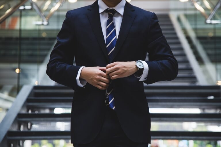 A man is buttoning his suit